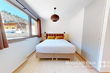 A bedroom with a bed and the words mountain base on the wall