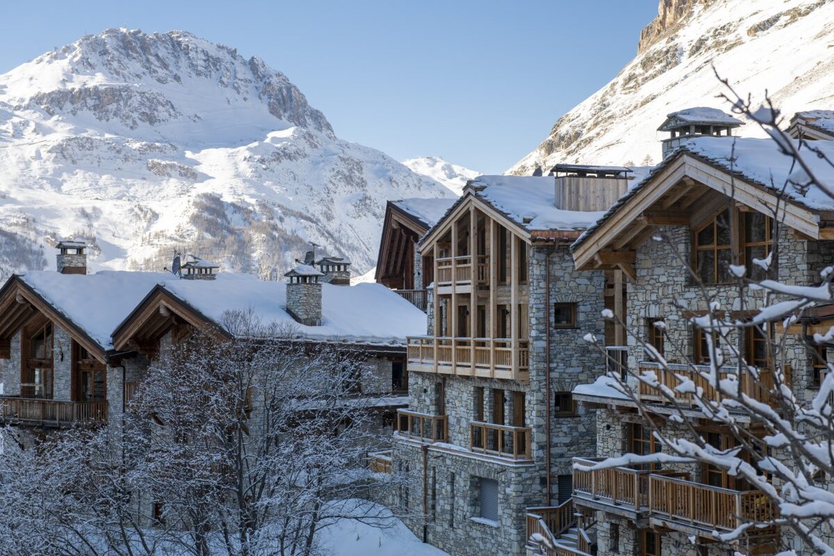Snow covered buildings with mountains in the background