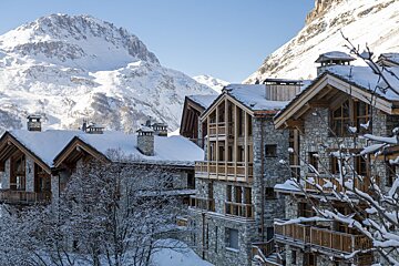 Snow covered buildings with mountains in the background