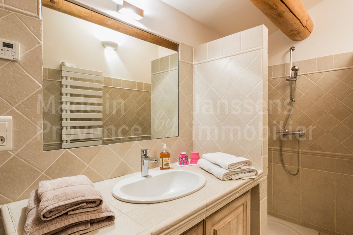 A bathroom with a sink and a mirror and the word janssens on the wall