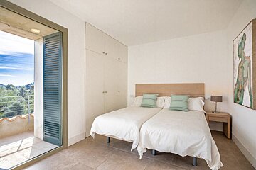 A bedroom with two beds and a painting on the wall