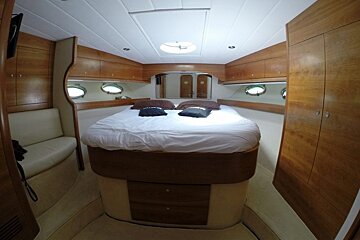 A bedroom on a boat with a bed and a couch