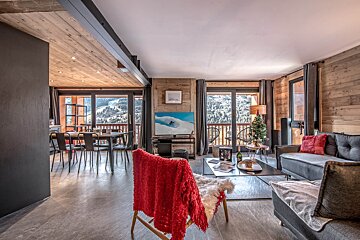 A living room with a couch and a chair with a red blanket on it