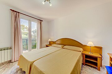 A bedroom with two beds and two lamps