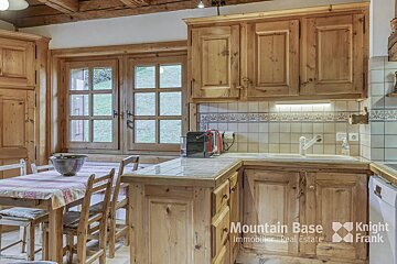 A kitchen with wooden cabinets and a knight frank logo