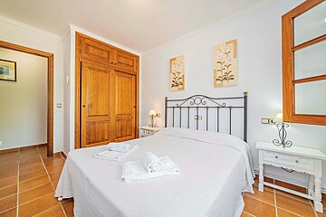 A bedroom with a wrought iron headboard and two nightstands