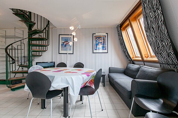A living room with a spiral staircase and a table and chairs