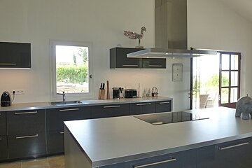 A kitchen with black cabinets and a stove top oven