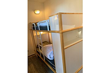 A bunk bed with a ladder and a blanket on it