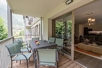 A balcony with a table and chairs and a sliding glass door