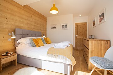 A bedroom with a large bed and a dresser