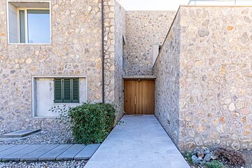 A stone building with a wooden door and shutters