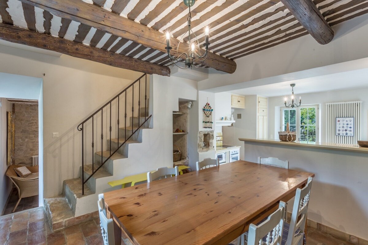 A dining room with a wooden table and chairs