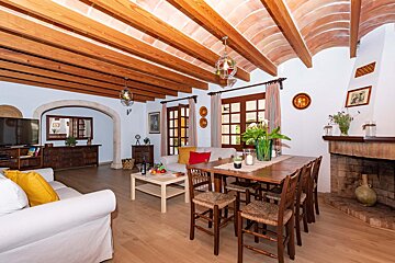 A living room with a table and chairs and a fireplace