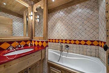 A bathroom with a red sink and a bathtub