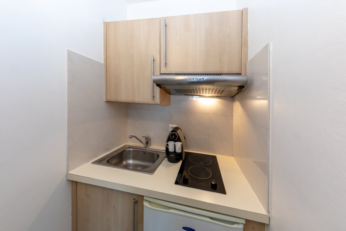 A small kitchen with a stove top oven and a sink