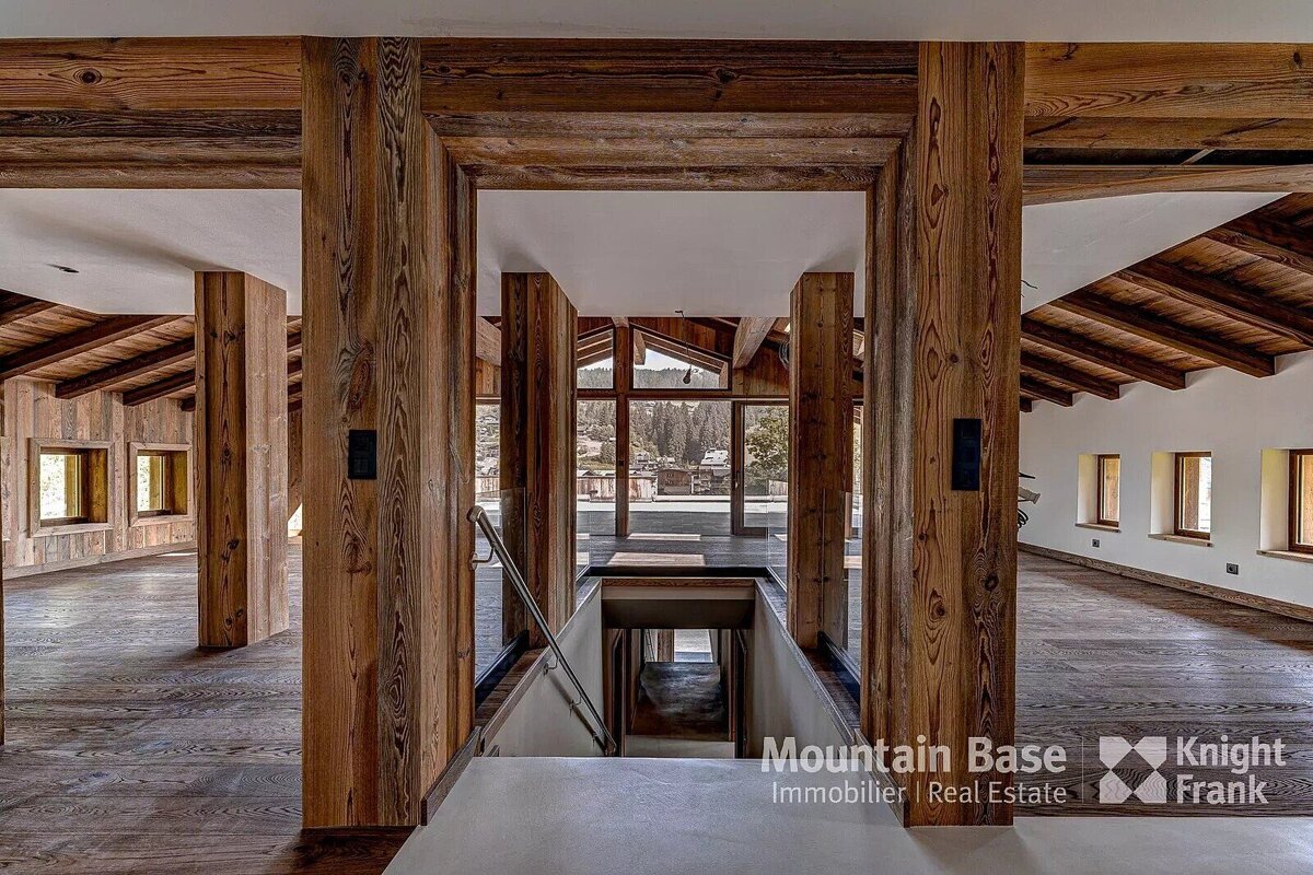 A room with wooden pillars and a sign that says mountain base