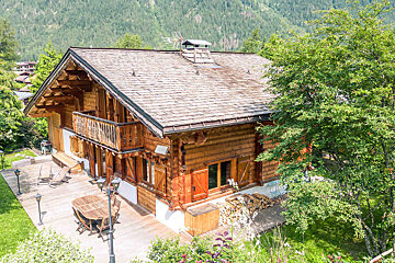 A snowy cabin with a mountain in the background