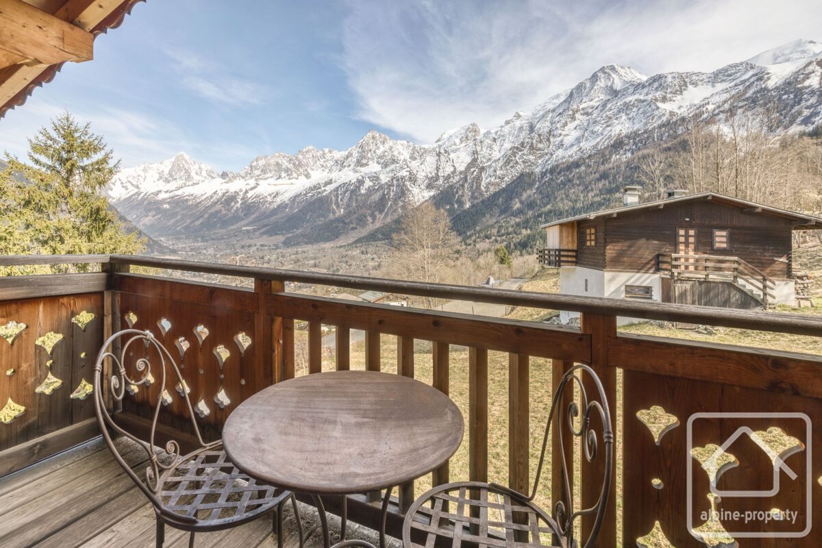 A balcony with a table and chairs and a sign that says alpine property