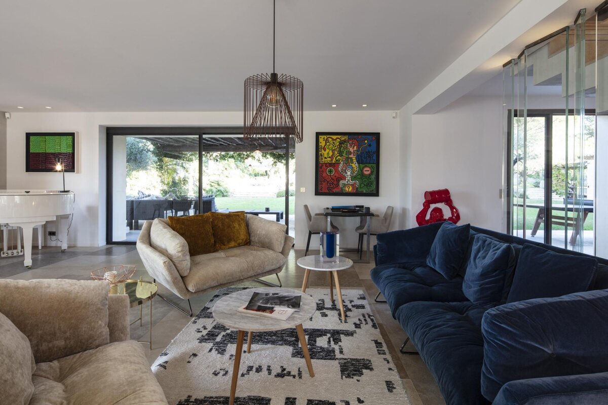A living room with a blue couch and a white piano