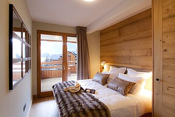 A bedroom with a bed and a sliding glass door