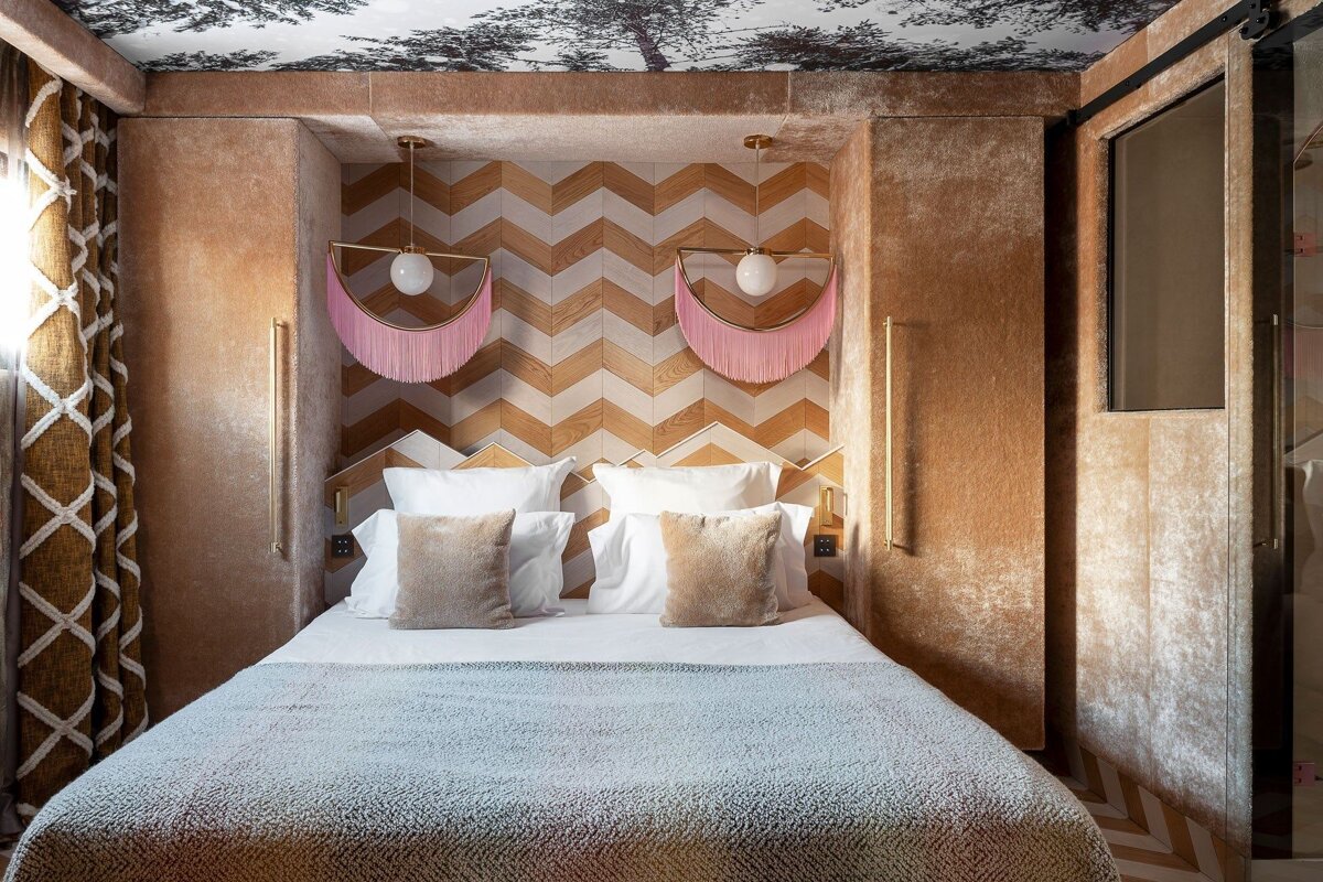 A bedroom with a chevron patterned wall and a bed
