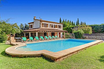 A house with a large swimming pool in front of it