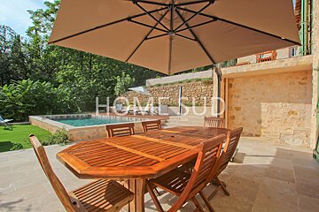 A table and chairs under an umbrella that says home sud