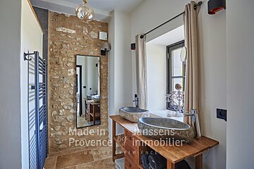 A bathroom with two sinks and a mirror made in provence by janssens immobilier