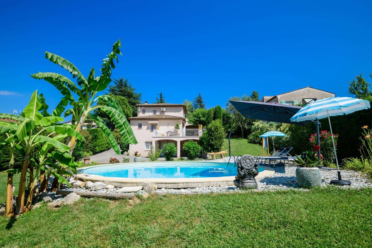 A large house with a swimming pool in front of it