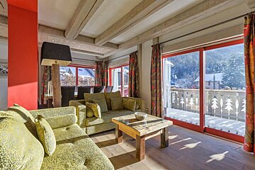A living room with a yellow couch and a wooden table