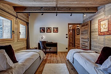 A bedroom with two twin beds and a desk