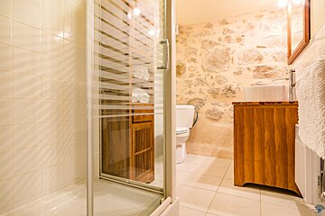 A bathroom with a toilet a sink and a walk in shower