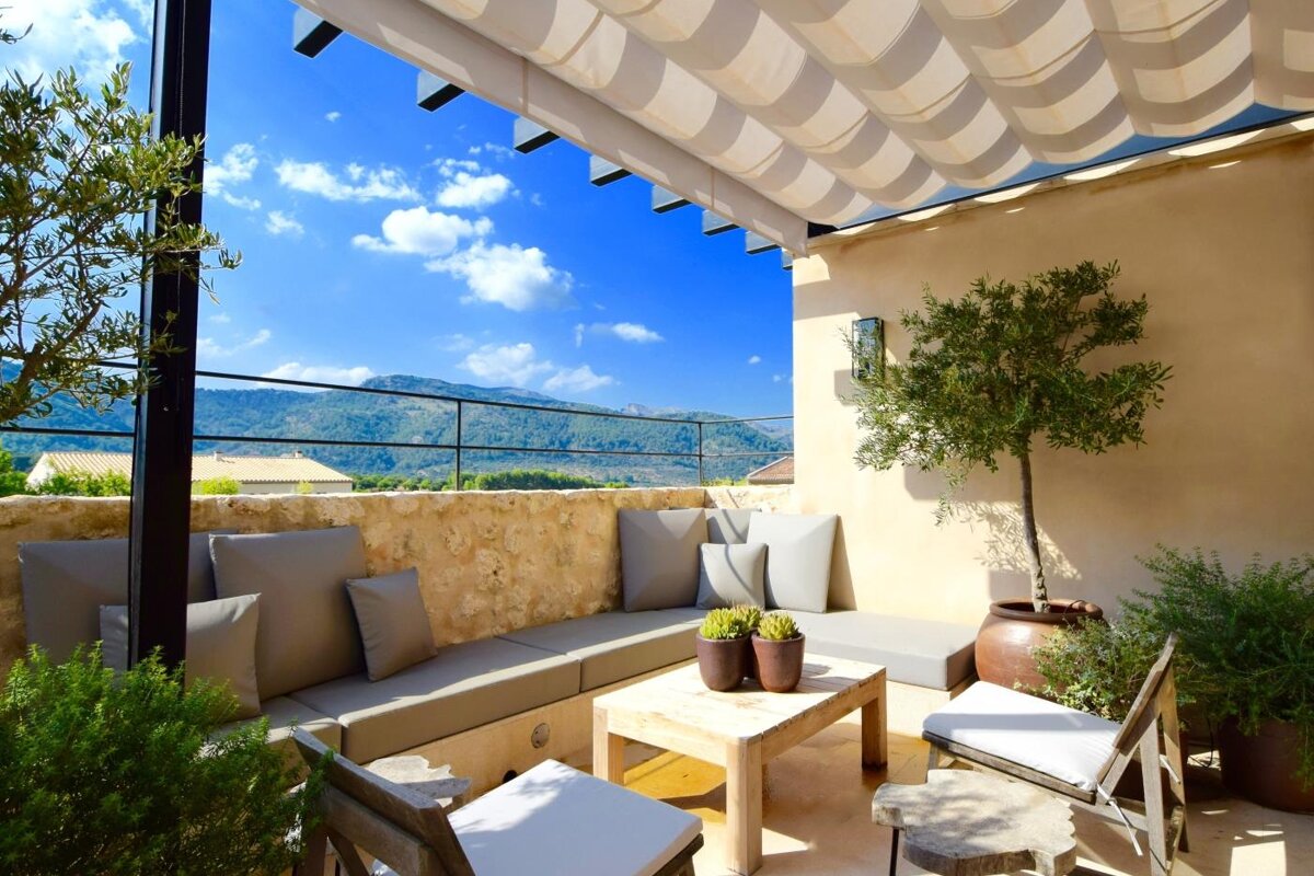 A patio with a couch and a table under a canopy