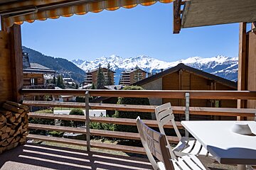 A balcony with a view of a snowy mountain range