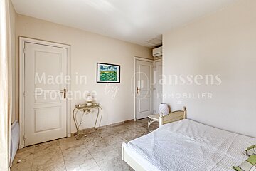 A bedroom with a bed and a door that says made in provence by janssens immobilier