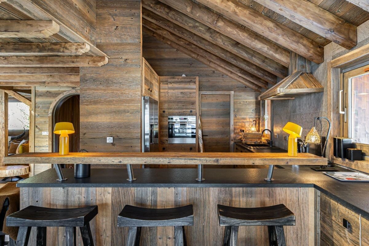 A kitchen with wooden walls and black counter tops