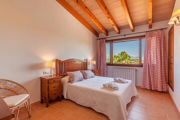 A bedroom with a large bed and a window