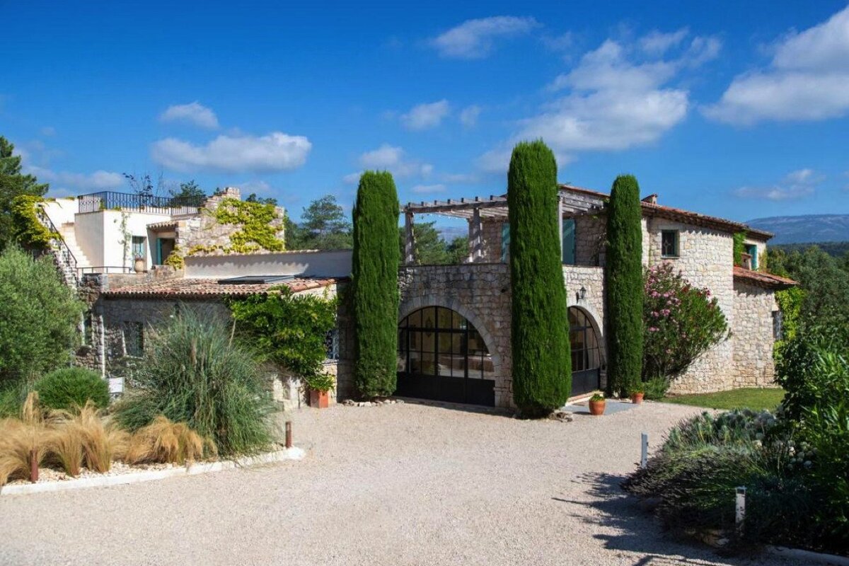 A large stone house with a driveway leading to it