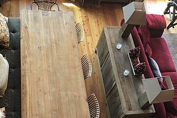 A living room with a red couch and a wooden table