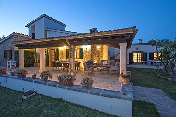 A house with a covered porch and a dining table and chairs
