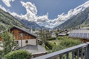 A view from a balcony of a mountain valley with the word teneo in the foreground
