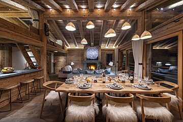 A dining room table with a bottle of wine on it