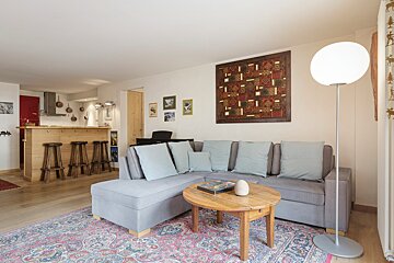 A living room with a couch a table and a lamp