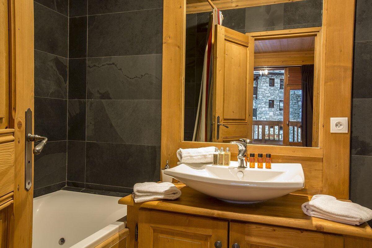 A bedroom with a painting of a wolf on the wall above the bed
