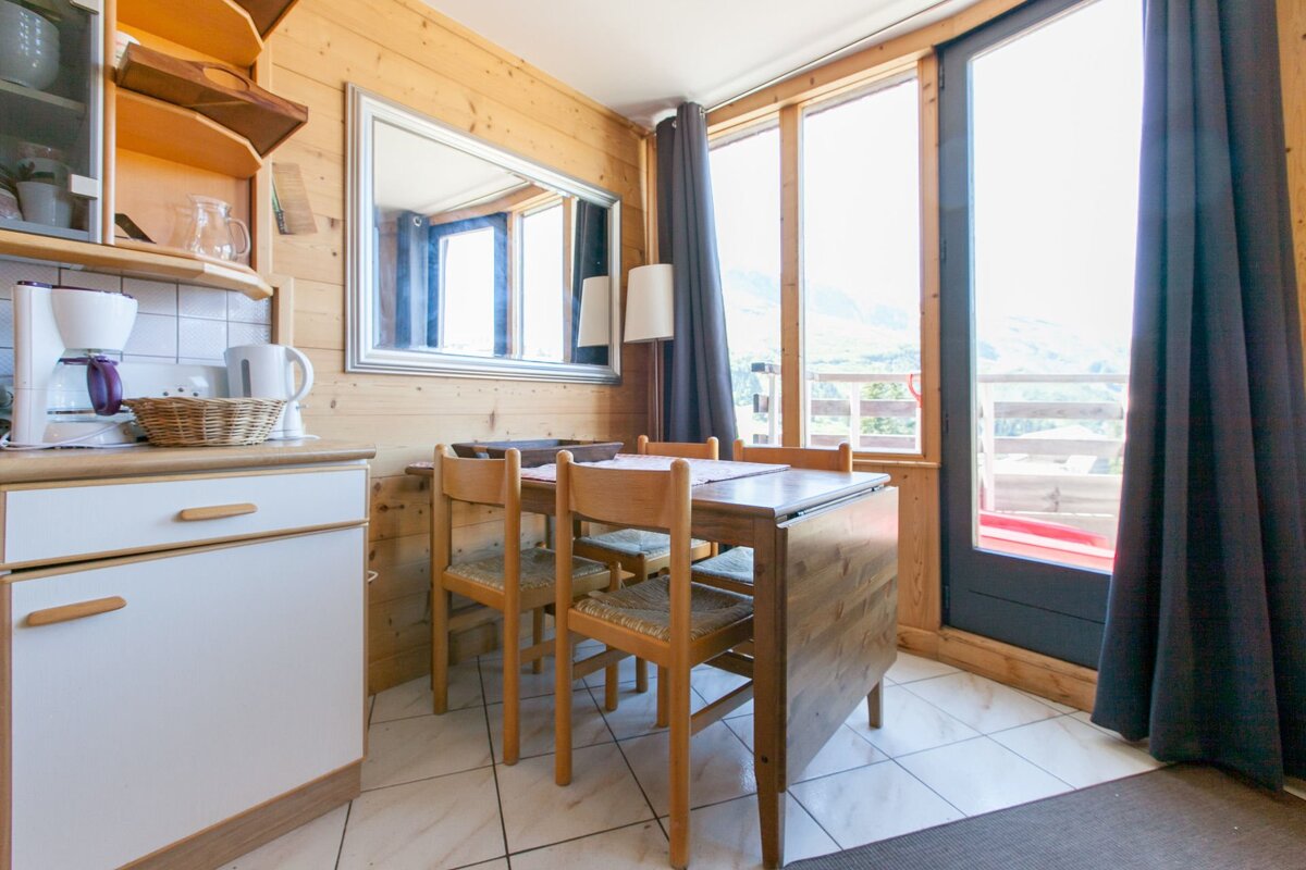 A kitchen with a table and chairs and a coffee maker