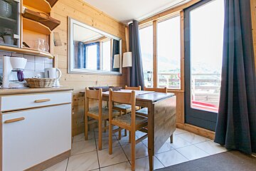 A kitchen with a table and chairs and a coffee maker