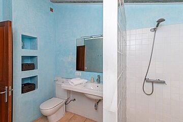 A bathroom with a toilet a sink and a shower