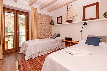 A bedroom with two beds and a sailboat on the wall