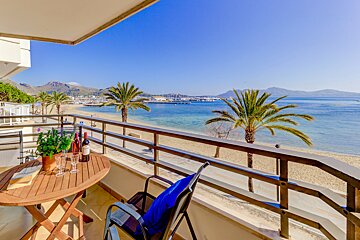 A balcony with a view of the ocean and palm trees